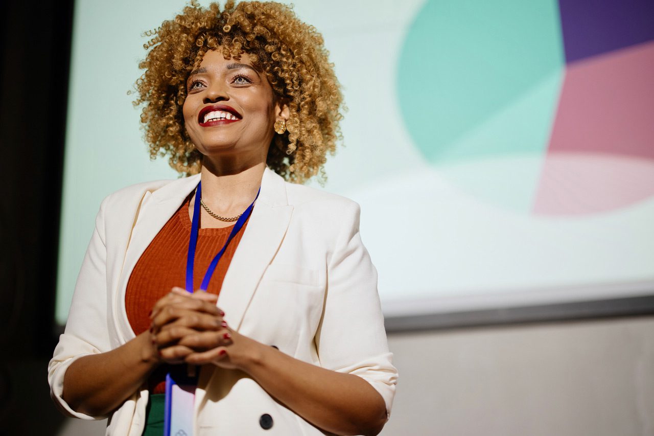 Close-up-of-a-visionary-female-speaker-smiling-and-looking-at-the-audience