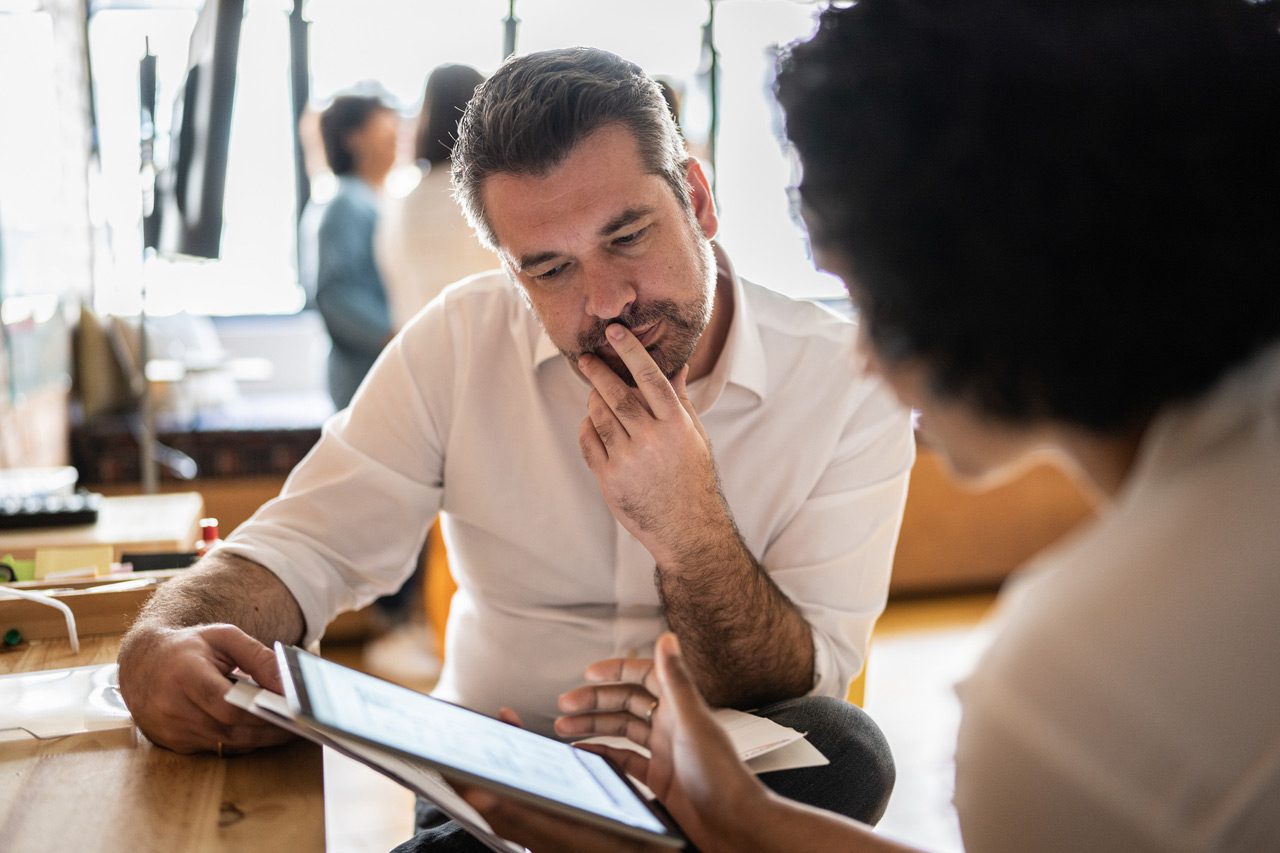 Mature-man-looking-at-a-digital-tablet-with-a-colleague