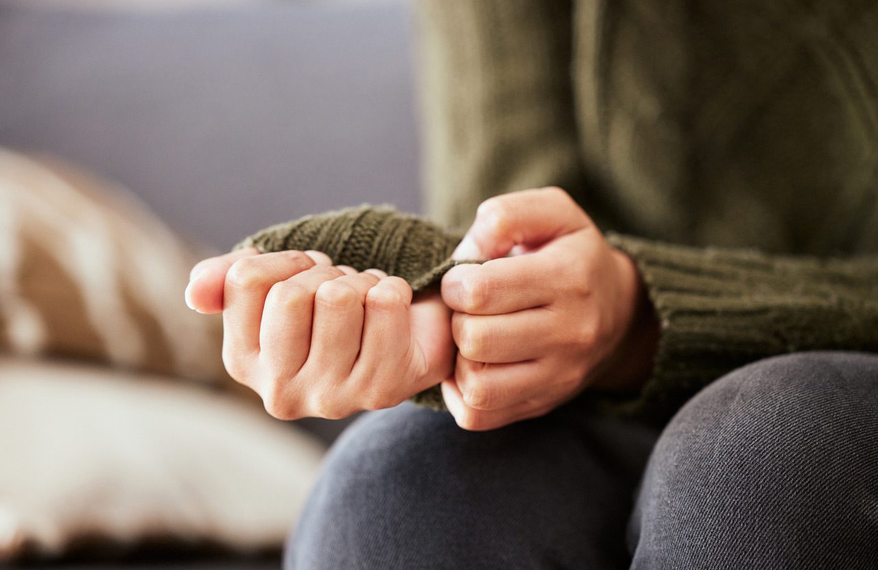 Woman-sitting-on-a-sofa-and-feeling-anxious