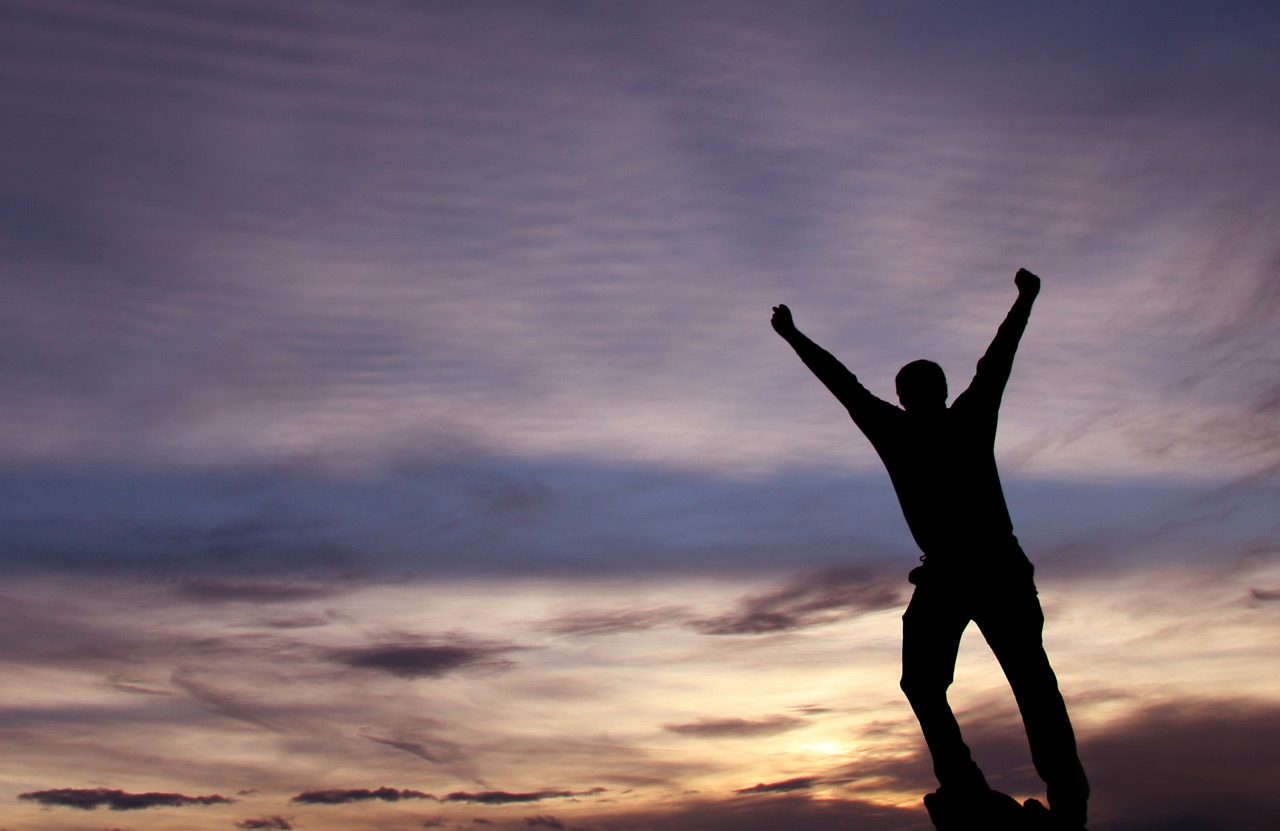 man-raising-his-arms-in-victory